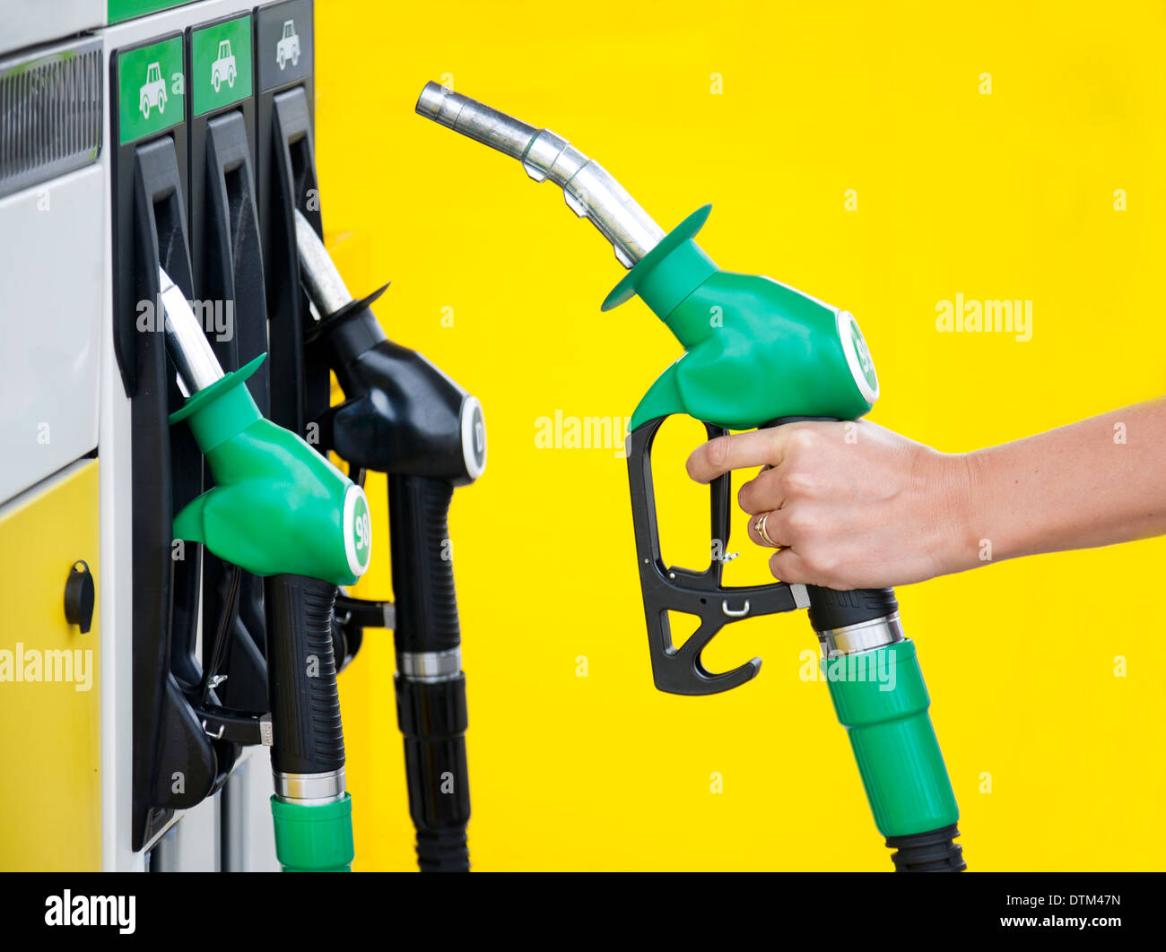 Woman`s hand holding gasoline pump. Petrol station. Nozzle. Stock Photo
